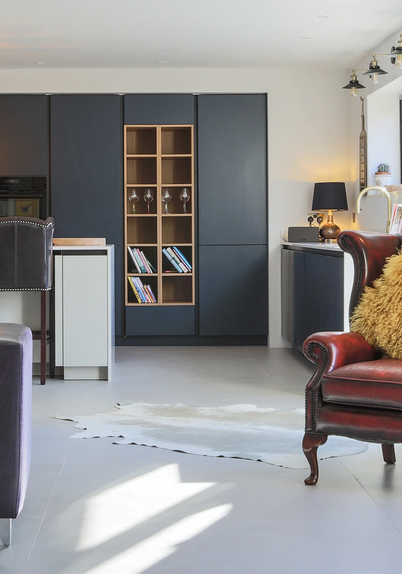 Bespoke dark cabinetry and a red leather armchair in a contemporary living space